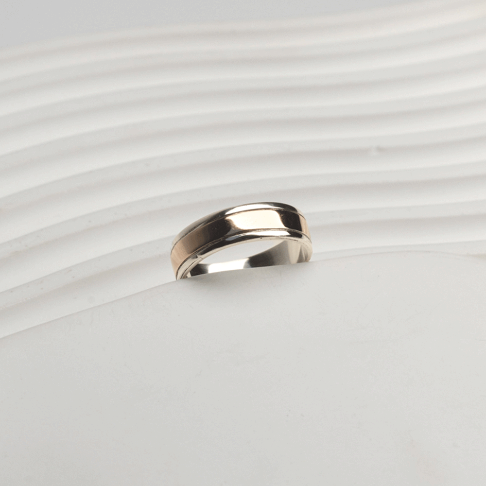 Vista inclinada del anillo Éternité en plata y oro 18K, con franja central de oro y bordes de plata pulida.