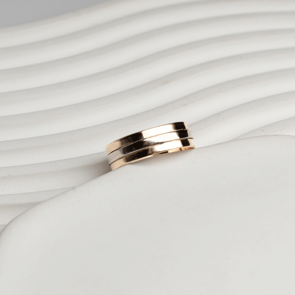Vista inclinada del anillo Alliance en oro blanco y oro rosado de 18K, con bandas pulidas sobre fondo blanco