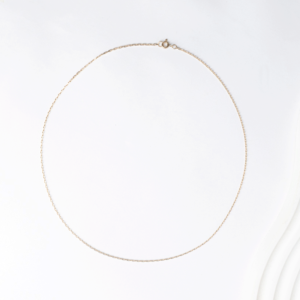 Cadena de eslabón tradicional en oro 18k, extendida en forma ovalada sobre fondo blanco.