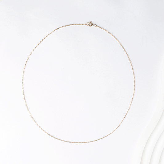 Cadena de eslabón tradicional en oro 18k, extendida en forma ovalada sobre fondo blanco.