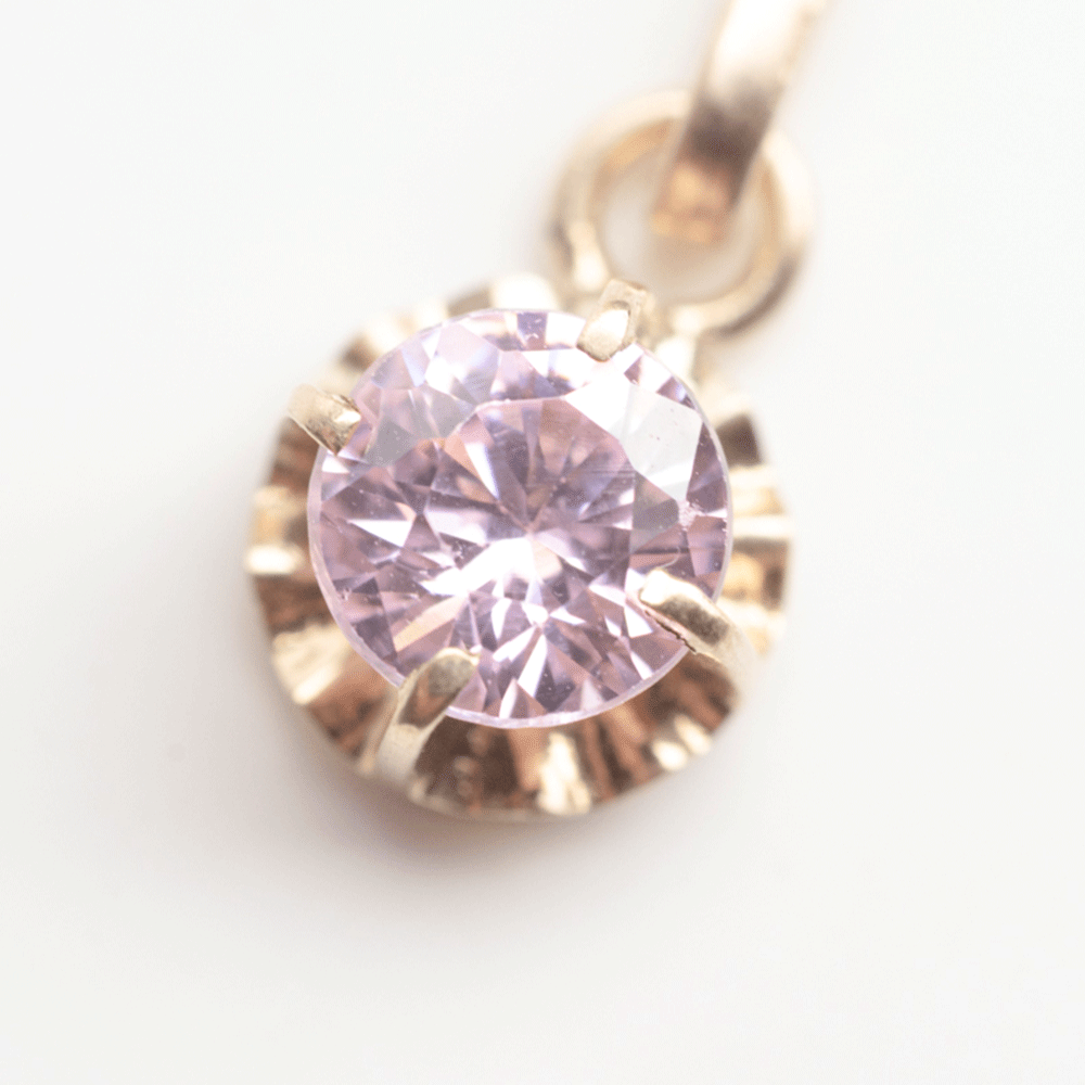 Detalle de la piedra Rosa de Francia facetada y su engaste en oro 18k en el colgante Punto de Luz.