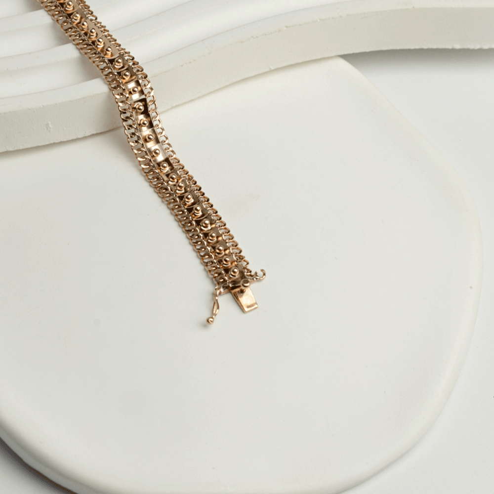 Pulsera Amaya en oro de 18k extendida sobre una superficie clara, con el cierre abierto