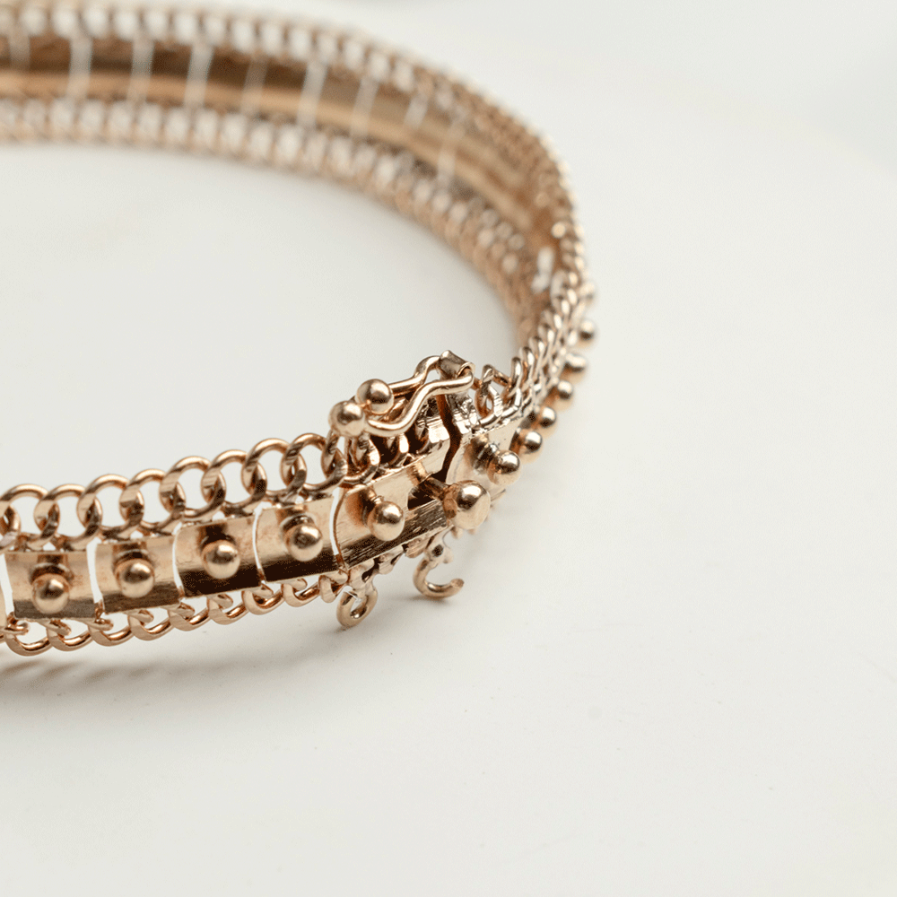 Detalle del cierre de la pulsera Amaya en oro de 18k, con vista de sus eslabones y adornos en relieve