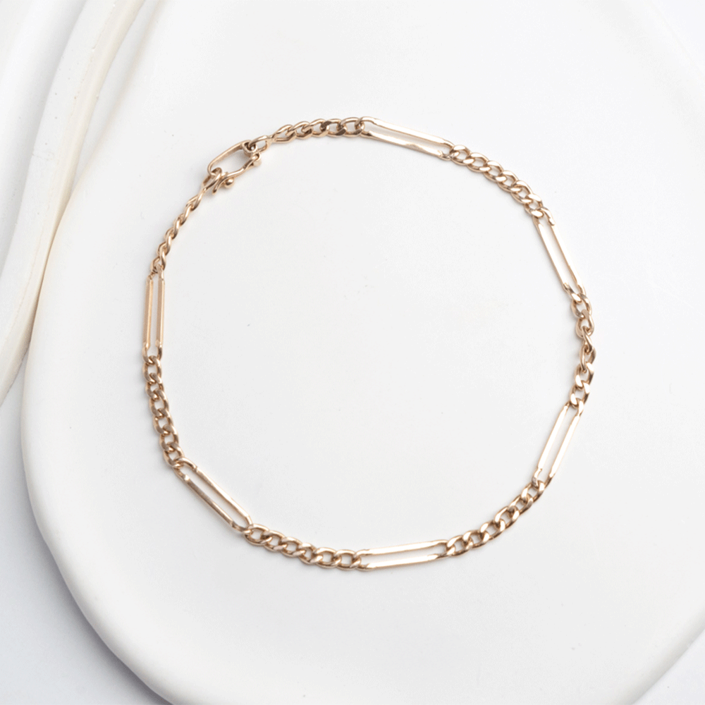 Pulsera diseño Cartier en oro de 18k, dispuesta en círculo sobre fondo blanco, con eslabones cortos y alargados