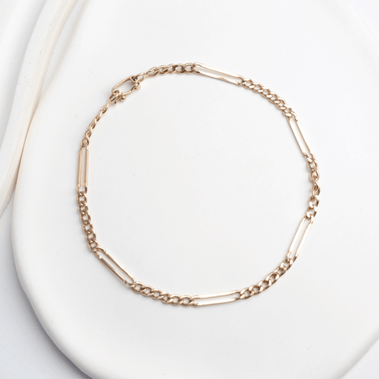 Pulsera diseño Cartier en oro de 18k, dispuesta en círculo sobre fondo blanco, con eslabones cortos y alargados