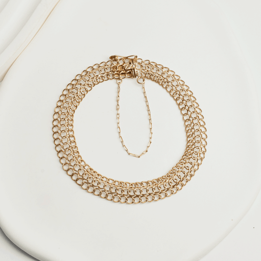 Pulsera Belle en oro de 18k sobre fondo claro, con varias hileras de eslabones redondos y cadena de seguridad visible
