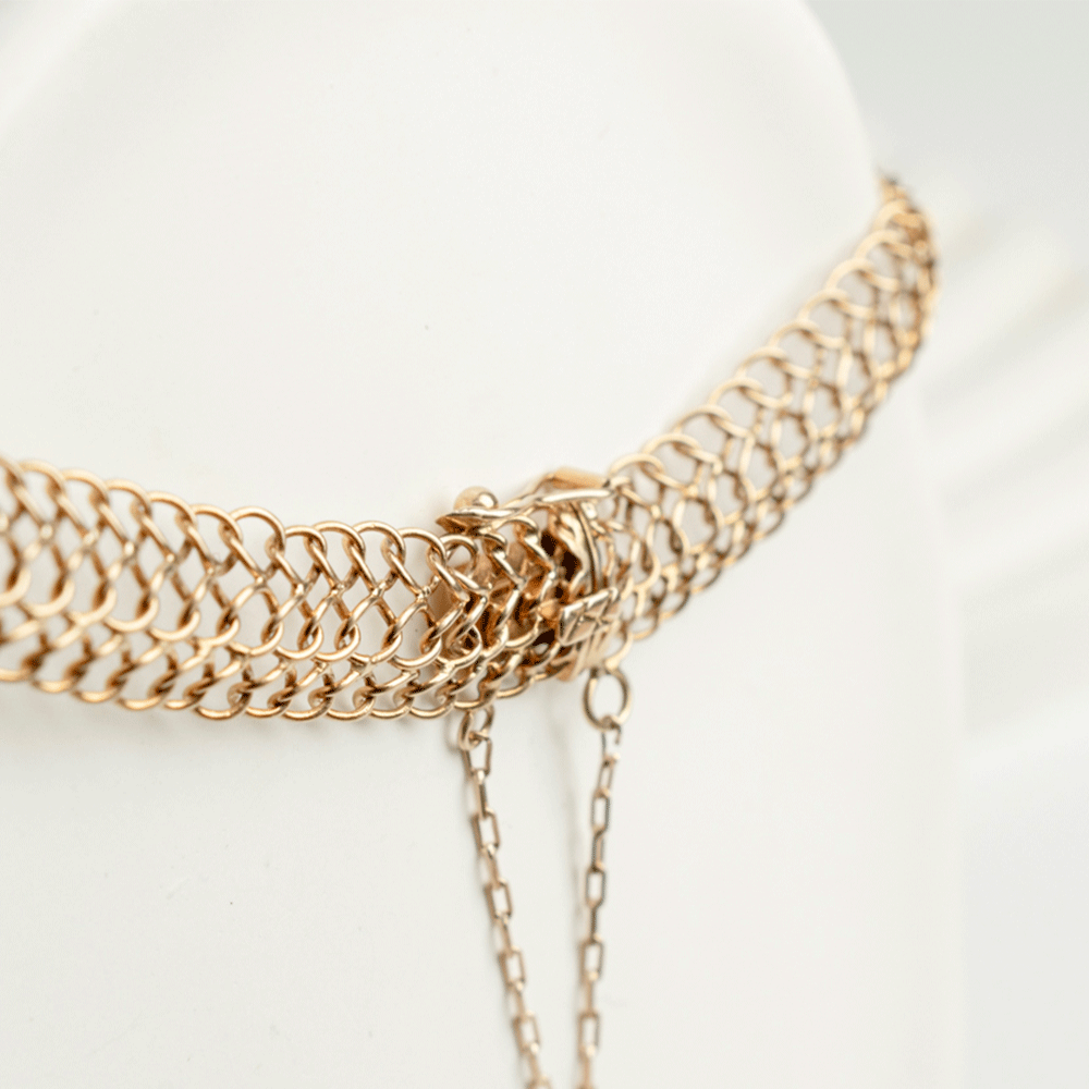 Detalle del cierre y la cadena de seguridad de la pulsera Belle en oro de 18k, con eslabones redondos entrelazados